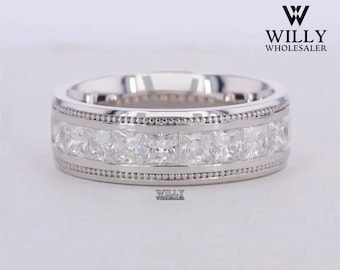 May include: A silver band ring with a row of square-shaped diamonds set in a channel setting. The band has a milgrain edge.