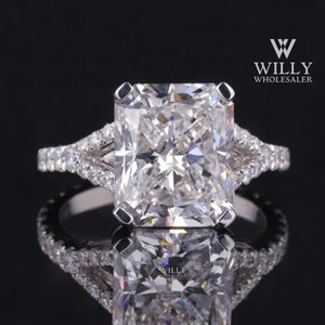Op de afbeelding: Een diamanten verlovingsring met een grote, vierkante middelste steen en een delicate, pavé-gezet band. De ring is gemaakt van witgoud en heeft een gesplitste schouder.