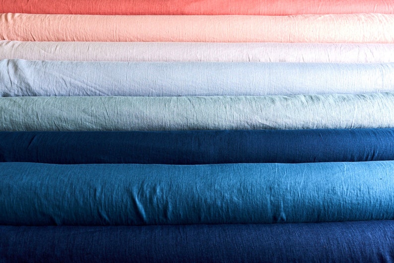 May include: A stack of fabric rolls in various shades of blue, green, pink, and red. The fabric is a linen blend and has a textured surface.