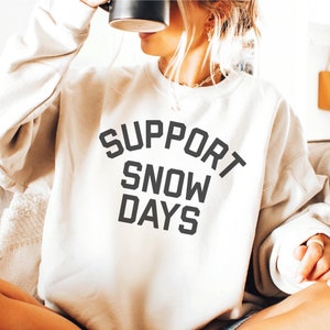 May include: A white sweatshirt with the text "SUPPORT SNOW DAYS" printed in black.