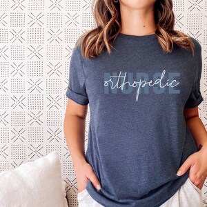 May include: A dark blue t-shirt with the text "orthopedic nurse" printed in white on the front.