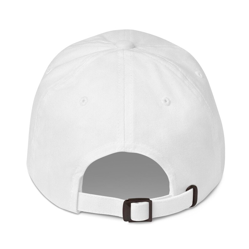 May include: A white baseball cap with a black adjustable strap. The cap is made of a soft, breathable fabric.