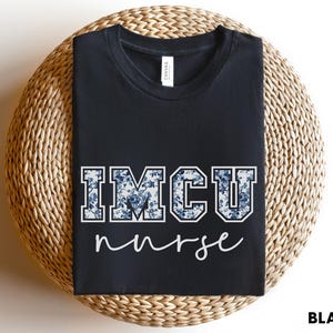 May include: Black t-shirt with a floral print design that says "IMCU nurse" in white lettering.