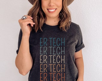 May include: A dark grey t-shirt with the text "ER TECH" repeated five times in a rainbow color gradient. The text is stacked vertically, with each line of text in a different color.
