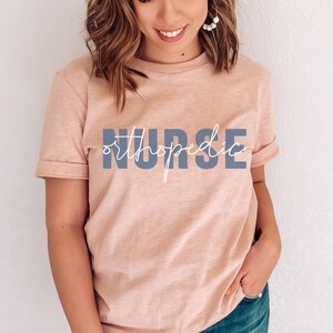 May include: A light pink t-shirt with the text "orthopedic NURSE" in blue and white lettering.