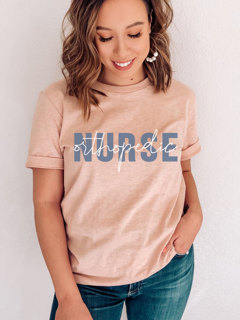 May include: A light pink t-shirt with the text "orthopedic NURSE" in blue and white lettering.