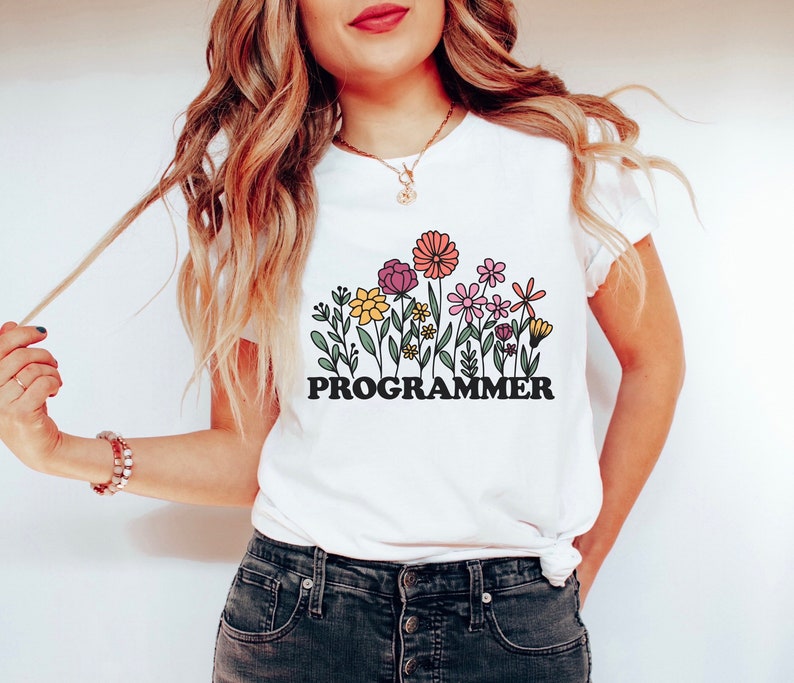 May include: White t-shirt with a graphic of colorful flowers and the text "PROGRAMMER".