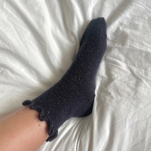 May include: Black ankle socks with a sparkly texture and a frilly edge.