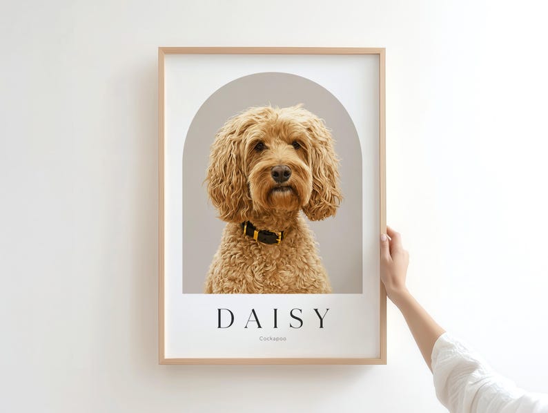 May include: A framed portrait print featuring a golden-brown Cockapoo dog with a black collar, centered within a gray arch graphic. The name DAISY is printed in black capital letters below the dog, with the word Cockapoo in smaller text.