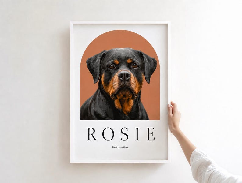 May include: A framed wall art print featuring a portrait of a black and tan Rottweiler dog centered within a terracotta-colored arch. Below the dog, the name ROSIE is printed in large black capital letters, with the word Rottweiler underneath.