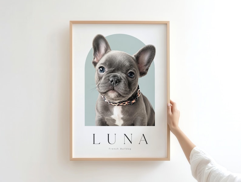 May include: A framed wall art print featuring a portrait of a gray French Bulldog puppy wearing a leopard print collar. The dog is centered against a sage green arch shape. Below the dog, the text reads LUNA and French Bulldog in black font.