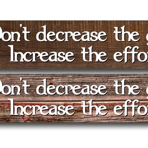 May include: Two rectangular wooden signs with the text "Don't decrease the goal, Increase the effort" in white. The top sign is a darker brown, and the bottom sign is a lighter brown with red accents. The text "USA MADE BY ME AT MY HOUSE" is in the left corner.