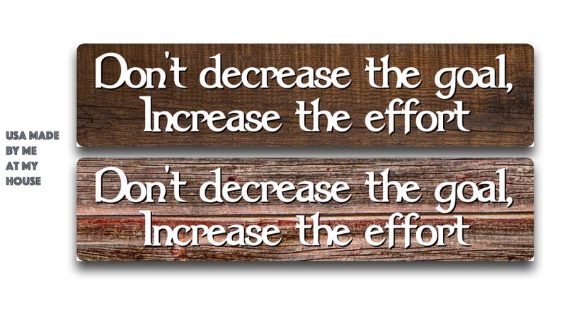 May include: Two rectangular wooden signs with the text "Don't decrease the goal, Increase the effort" in white. The top sign is a darker brown, and the bottom sign is a lighter brown with red accents. The text "USA MADE BY ME AT MY HOUSE" is in the left corner.