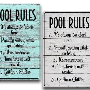 May include: Two rectangular wooden signs with the text "POOL RULES" in black. The signs list pool rules, including "It's always 5 o'clock here" and "Grillin n Chillin." One sign is light blue, the other is white.