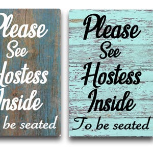May include: Two wooden signs with a distressed blue and turquoise paint finish. The signs read "Please See Hostess Inside To Be Seated".