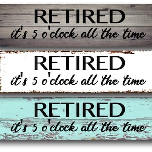 May include: Three rectangular wooden signs with the word "RETIRED" and the phrase "it's 5 o'clock all the time" in black text. The signs are in shades of gray, white, and teal, with a distressed wood appearance.