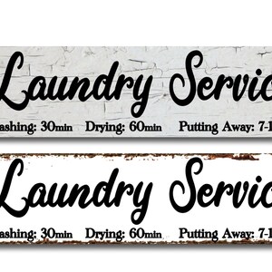 May include: Two white wooden signs with black text that reads "Laundry Service" and "Washing: 30min Drying: 60min Putting Away: 7-10days". The signs have a distressed, vintage look.