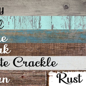 May include: A rustic wooden sign featuring various color swatches with text labels. The colors include grey, teal, blue, dark brown, white crackle, barn, and rust. The sign has a weathered, distressed appearance.