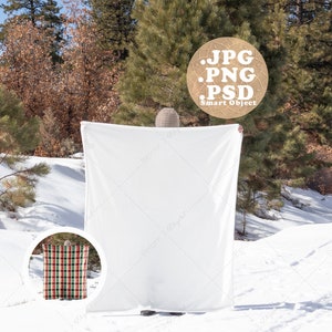 May include: A white blanket mockup in a snowy winter scene. The blanket is held up by a person wearing a hat. The text "JPG .PNG .PSD Smart Object" is visible in the image.