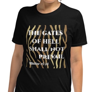May include: Black t-shirt with a gold and brown zebra print design. The text "The Gates of Hell Shall Not Prevail" is printed in white on the shirt. The text "Matthew 16:18" is printed in white below the main text.