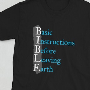 May include: Black short-sleeve t-shirt with the word "BIBLE" in white and the phrase "Basic Instructions Before Leaving Earth" in blue. The shirt is made of a soft material.