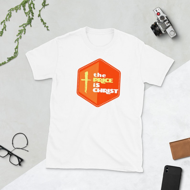 Peut inclure: T-shirt blanc avec un graphique hexagonal orange qui dit "the price is christ" avec une croix jaune &agrave; l'int&eacute;rieur de l'hexagone.