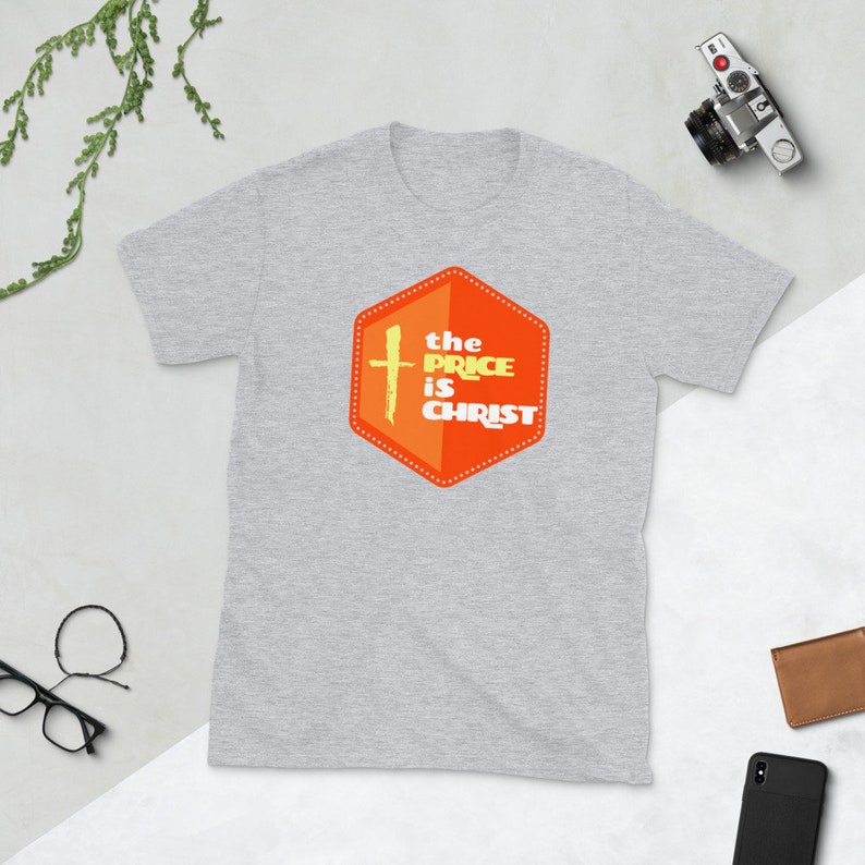 Peut inclure: T-shirt gris avec un graphique hexagonal orange et jaune qui dit "the price is christ" avec une croix &agrave; l'int&eacute;rieur de l'hexagone.