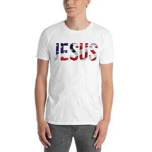 May include: White t-shirt with the word "JESUS" printed in red, white, and blue, resembling the American flag.