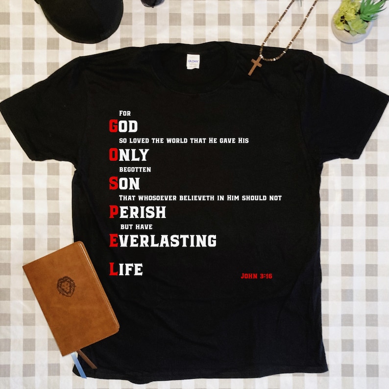 May include: Black t-shirt with white text that reads "For God So Loved The World That He Gave His Only Begotten Son That Whosoever Believeth In Him Should Not Perish But Have Everlasting Life" and "John 3:16".