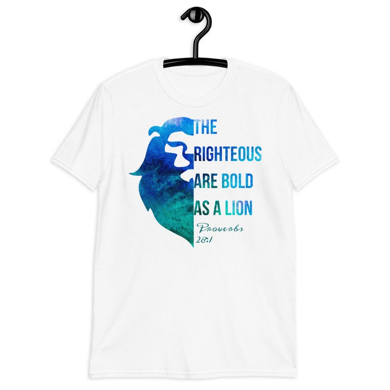 Pode incluir: Camiseta branca com um design de cabe&ccedil;a de le&atilde;o em aquarela azul e verde. O texto "THE RIGHTEOUS ARE BOLD AS A LION Proverbs 28:1" est&aacute; impresso na camiseta.