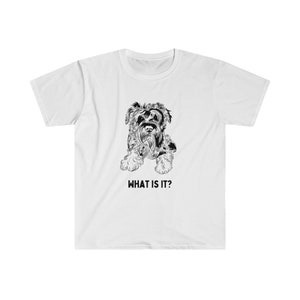 May include: White t-shirt with a black and white illustration of a small dog with the text "WHAT IS IT?" printed below the image.