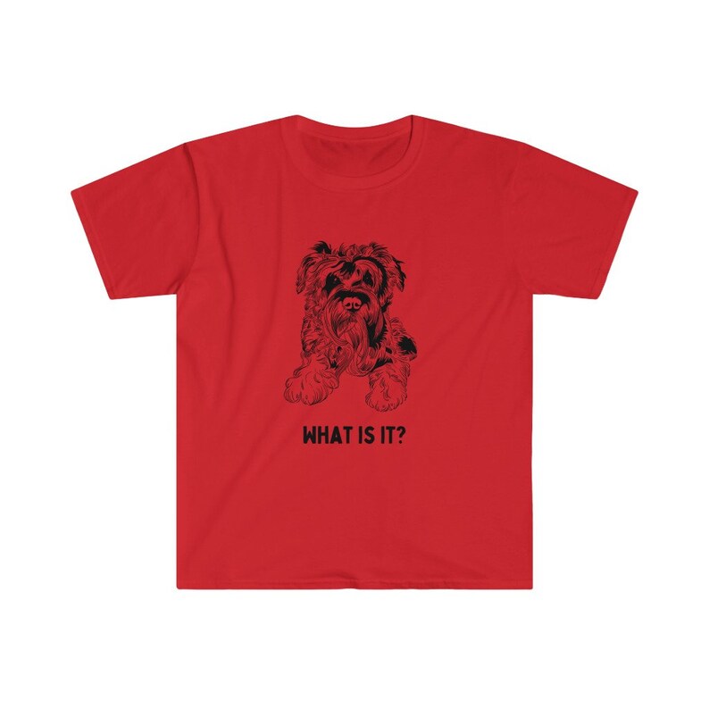 May include: Red t-shirt with a black and white illustration of a small dog. The text "WHAT IS IT?" is printed below the dog.