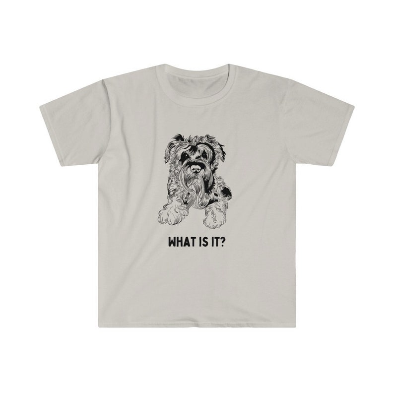 May include: A light grey t-shirt with a black and white illustration of a small dog. The text "WHAT IS IT?" is printed below the dog.