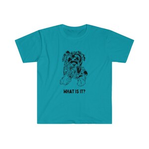 May include: A turquoise blue t-shirt with a black and white illustration of a dog. The text "WHAT IS IT?" is printed below the image.