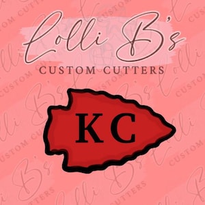 May include: Red and black arrowhead cookie cutter with the letters KC in the center. The cutter is on a pink background with the text "Lolli B's Custom Cutters" in black.