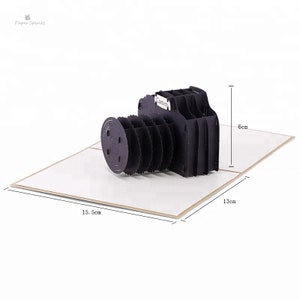 May include: A black paper pop-up card shaped like a camera. The card is 15.5 inches wide, 13 inches long, and 6 inches tall.