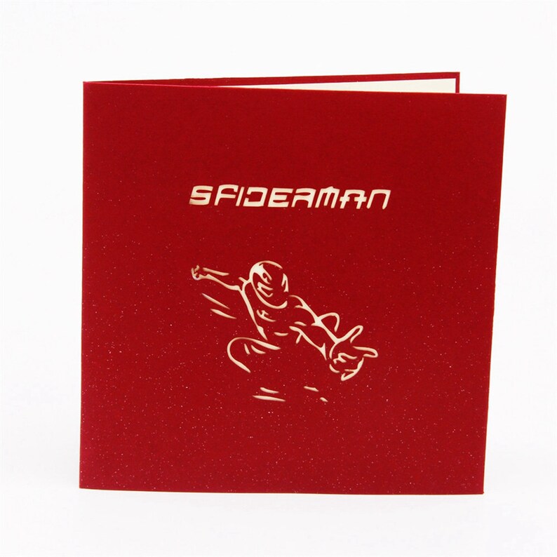 May include: Red pop-up card with a white silhouette of Spiderman swinging through the air. The card says "SPIDERMAN" in white letters.