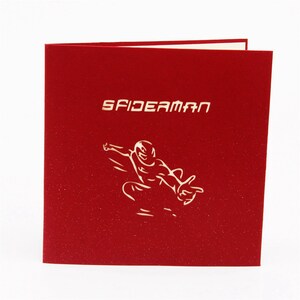May include: Red pop-up card with a white silhouette of Spiderman swinging through the air. The card says "SPIDERMAN" in white letters.