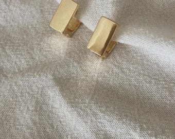 May include: A pair of gold-toned rectangle shaped earrings.