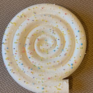 Set of two bright white lollipops with confetti sprinkles. 17 inch diameter