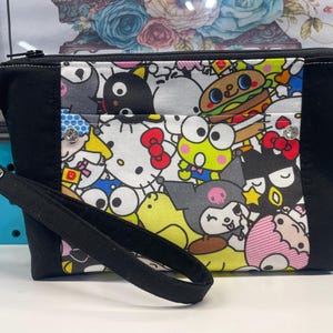 Cartera de pulsera confeccionada en tejido con licencia de Hello Kitty y sus amigos