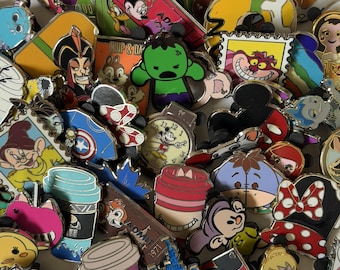 May include: A large collection of colorful metal enamel pins featuring various cartoon characters, including a green superhero, a smiling cat, a clock, coffee cups, and iconic mouse ears, all arranged in a dense, overlapping pile.