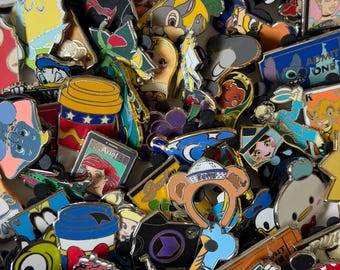 May include: A large collection of colorful metal enamel pins featuring various cartoon characters, including Disney figures, coffee cups, and themed icons, arranged in a dense, overlapping pile with diverse shapes and vibrant designs.