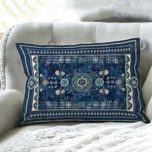 May include: A rectangular throw pillow featuring a deep blue base with a detailed, symmetrical pattern in shades of cream, light blue, and green. The design includes intricate floral motifs, geometric borders, and a central medallion element.