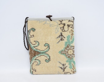 May include: A small beige and blue patterned fabric pouch with a brown drawstring closure. The pouch is made from a woven fabric with a floral design.