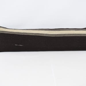 May include: A long brown and white striped pillow. The pillow is made of a soft, woven fabric and has a subtle sheen.