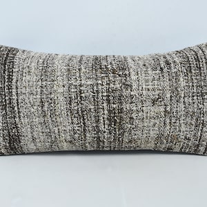 May include: A rectangular pillow with a brown and white geometric pattern. The pillow is made of a soft, woven fabric.