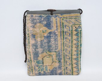 May include: A blue and beige drawstring bag made from a woven rug with a geometric pattern. The bag has a gray fabric lining and brown drawstrings.