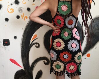 May include: A black crochet dress with colorful circular patterns. The dress features a halter neckline and a fringe hem. The circles are in shades of red, green, pink, blue, and orange. The dress is handmade.