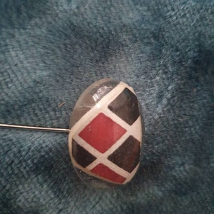 May include: A clear resin cabochon with a black and red diamond pattern. The cabochon is a popular choice for jewelry making and crafting.
